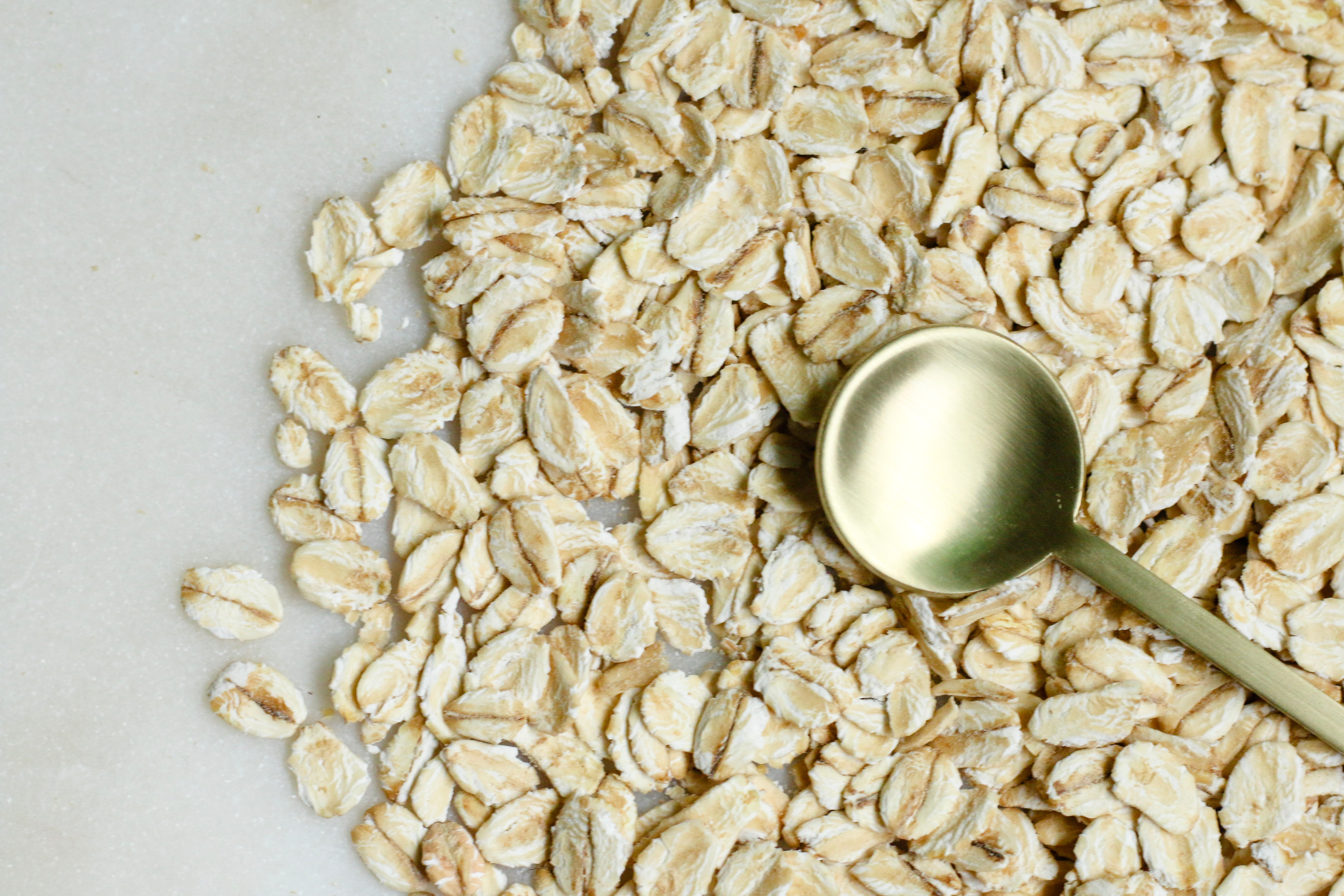 Oats on a surface with gold spoon