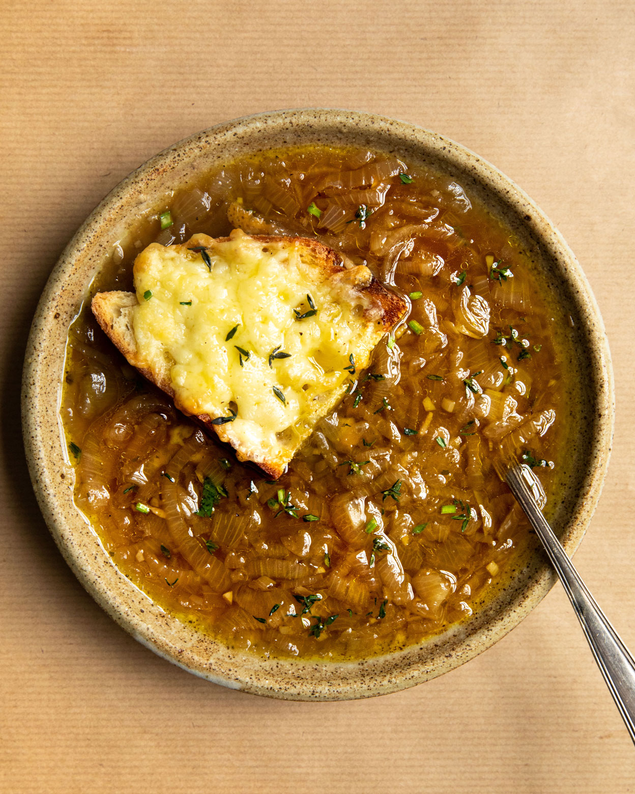 vegan french onion soup in a bowl with spoon