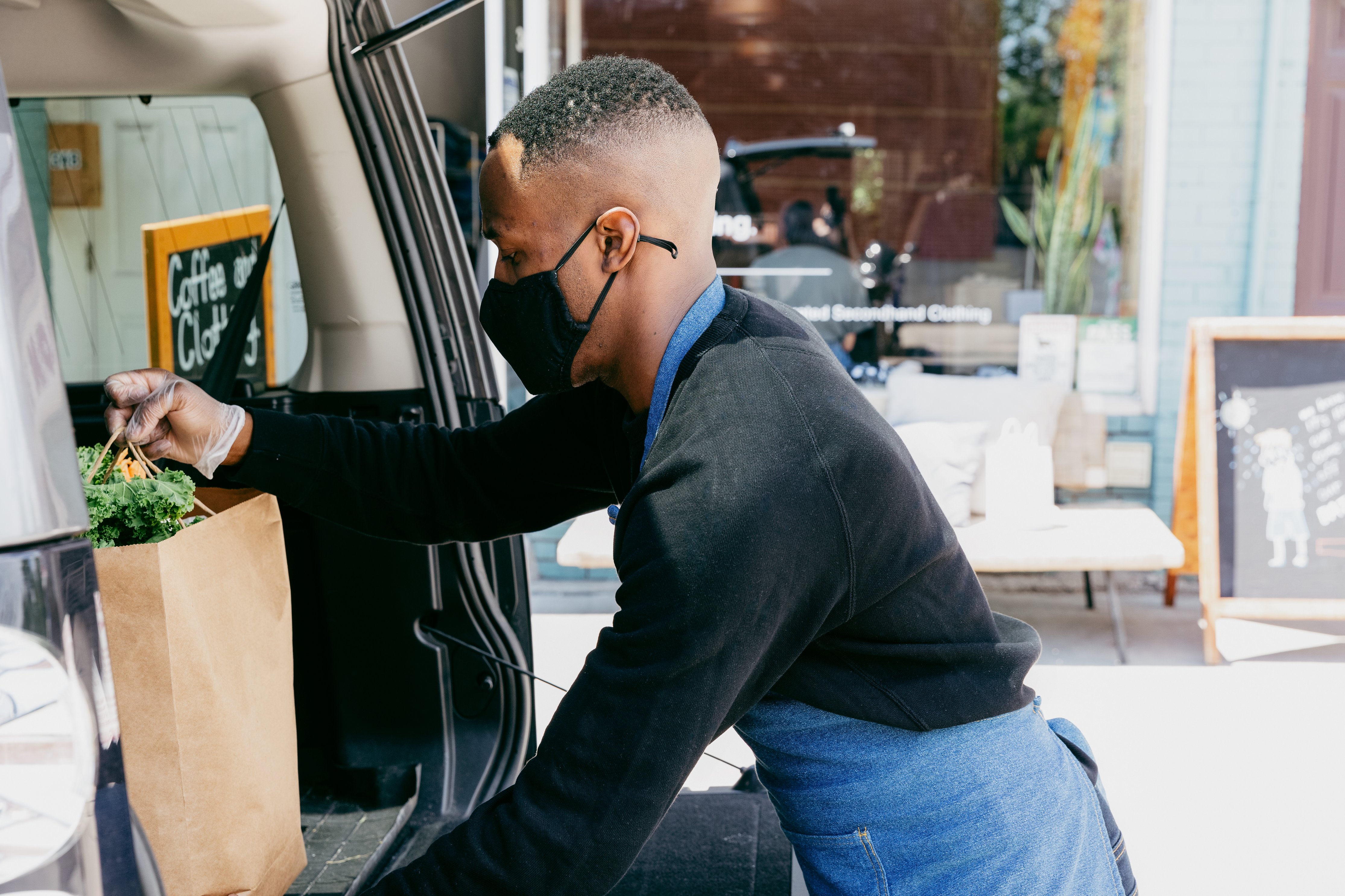 man putting groceries into car