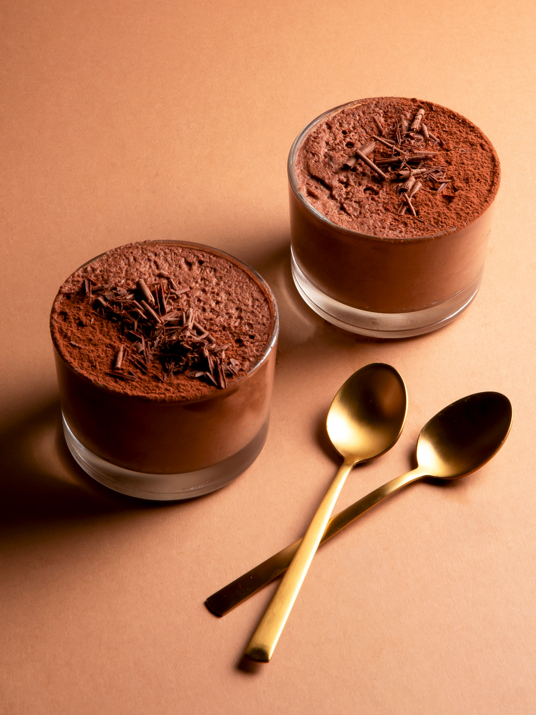2 servings of chocolate mousse, garnished with chocolate shavings and powder