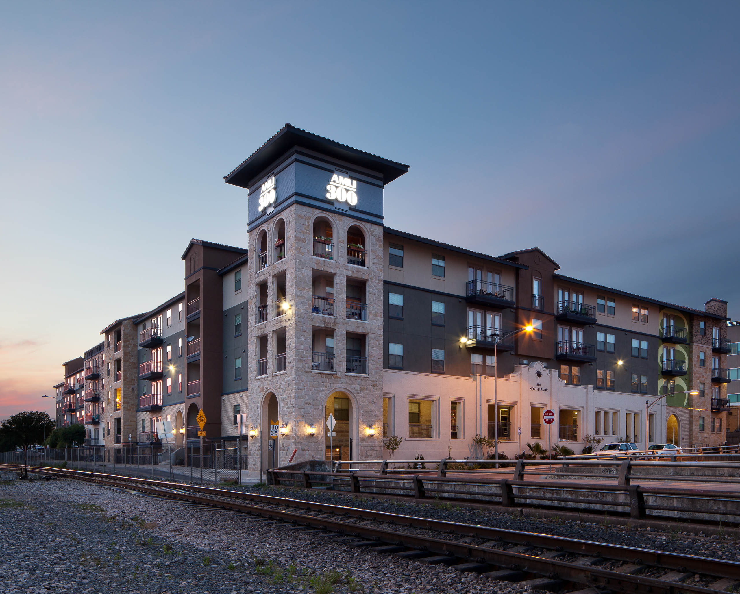 Exterior view of daytime AMLI 300 apartment building's brick facade in downtown Austin