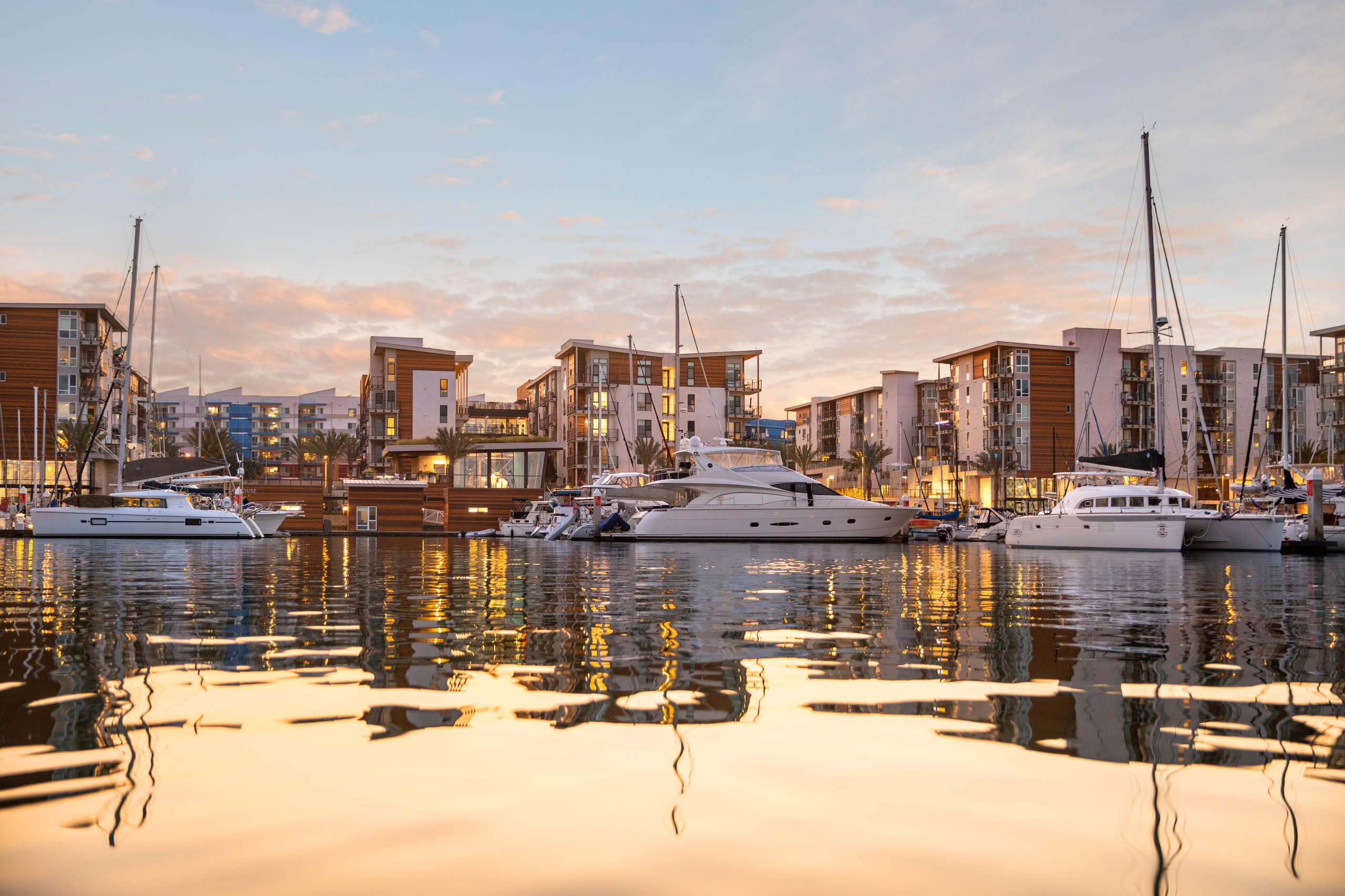 Dusk view of marina with boats docked in front of apartment buildings at AMLI Marina Del Rey