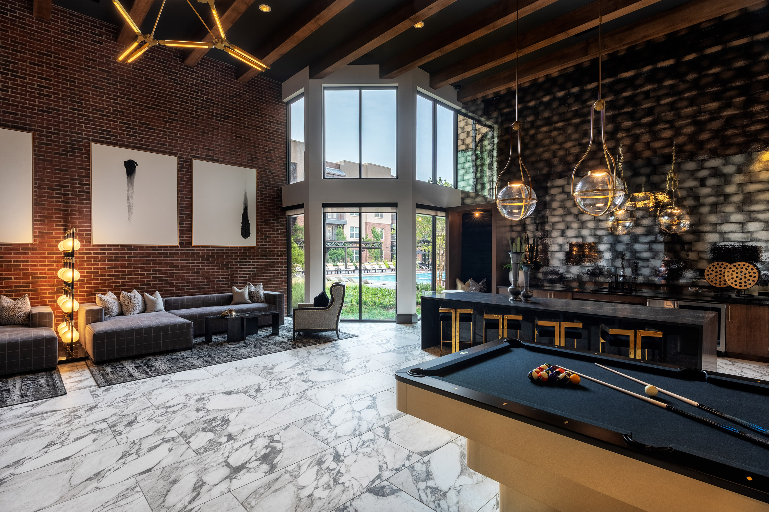 AMLI Grapevine apartment building clubroom with gray tile flooring and catering kitchen and lounge seating and pool table