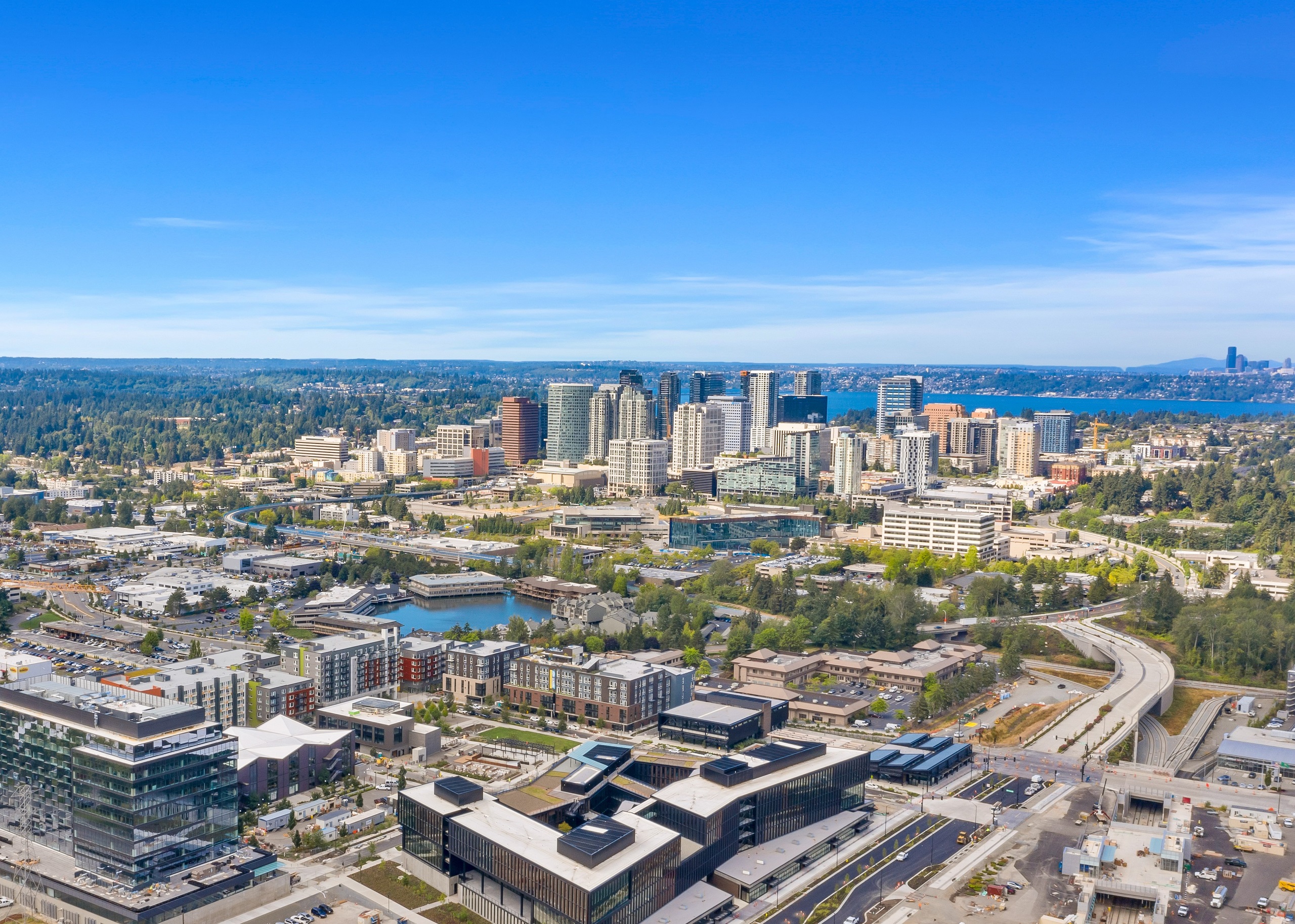 Aerial view of AMLI Spring District apartment building with surrounding Bellevue neighborhood and lake behind buildings