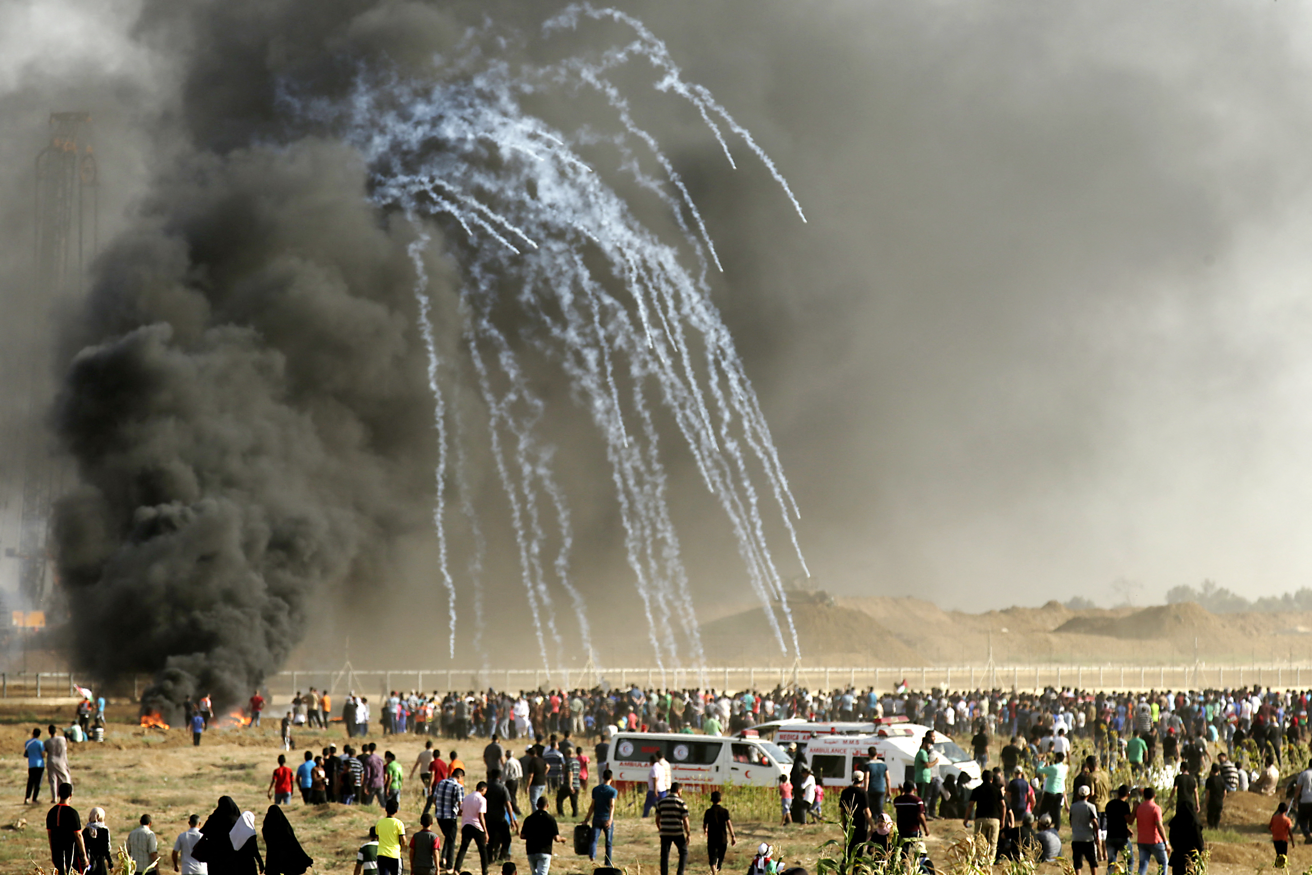 Palestinian protesters run for cover after Israeli forces launched tear gas canisters during a demonstration along the border between the Gaza strip and Israel, east of Gaza city on June 22, 2018.
MAHMUD HAMS / AFP