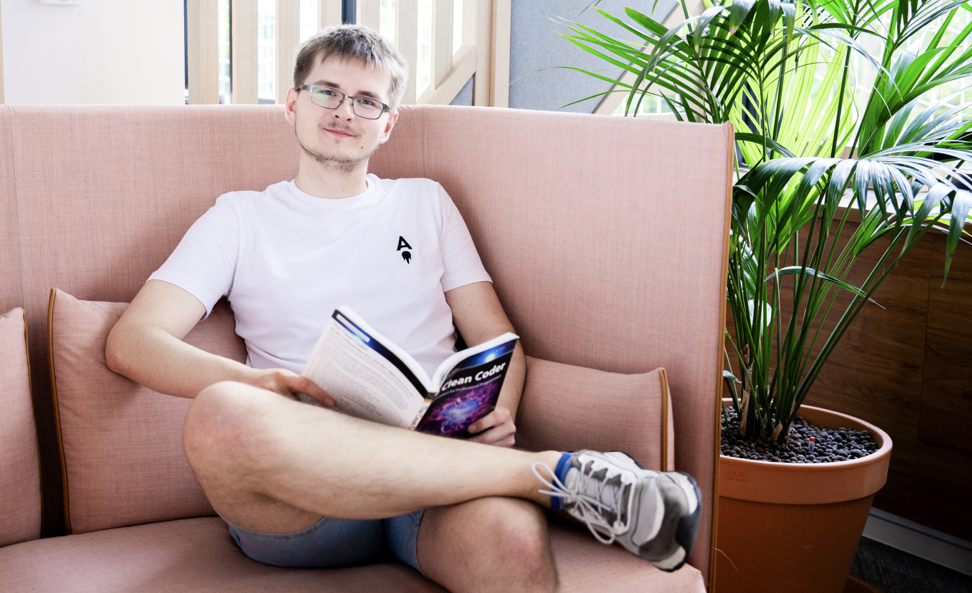 developer sitting on a sofa with a book in his hands
