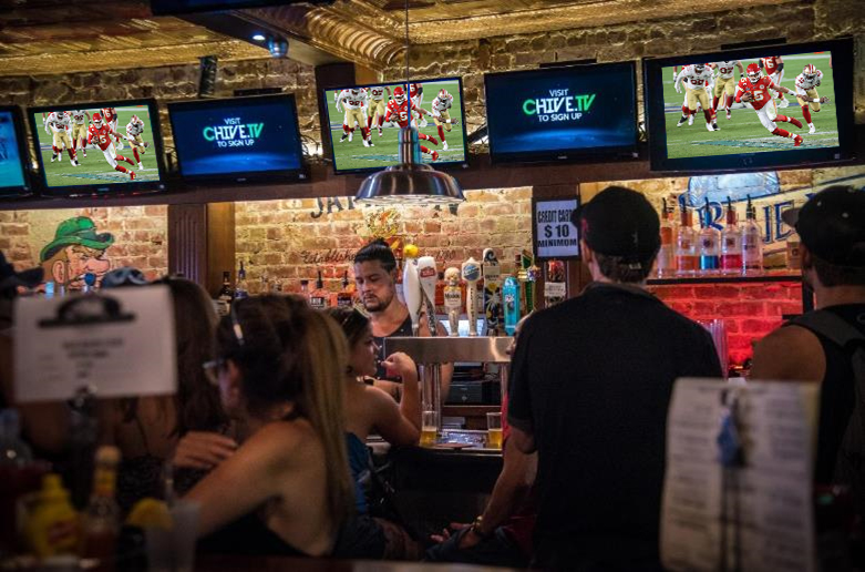 Bar goers viewing Chive TV next to the Kansas City Chiefs game
