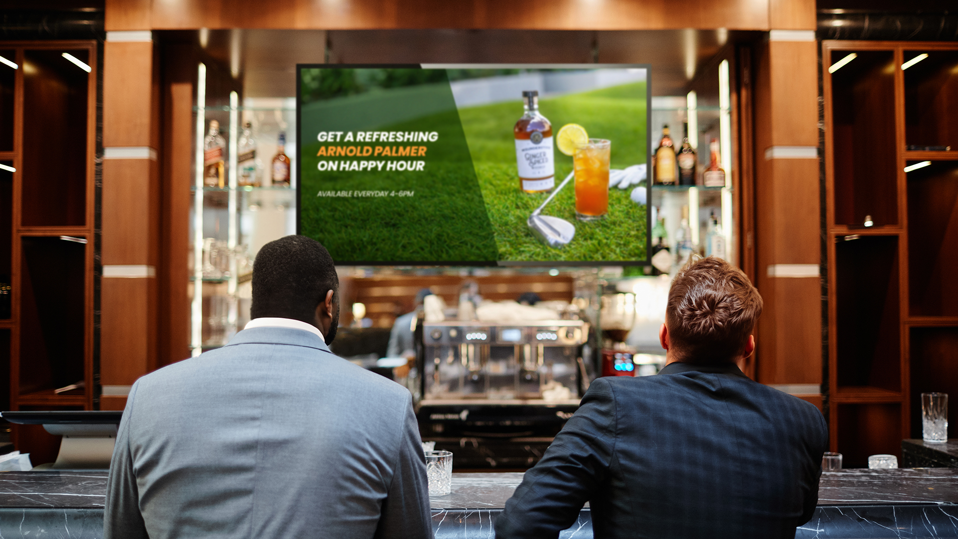 Two people watching Atmosphere TV at a bar engaging with an on-screen promotion. 