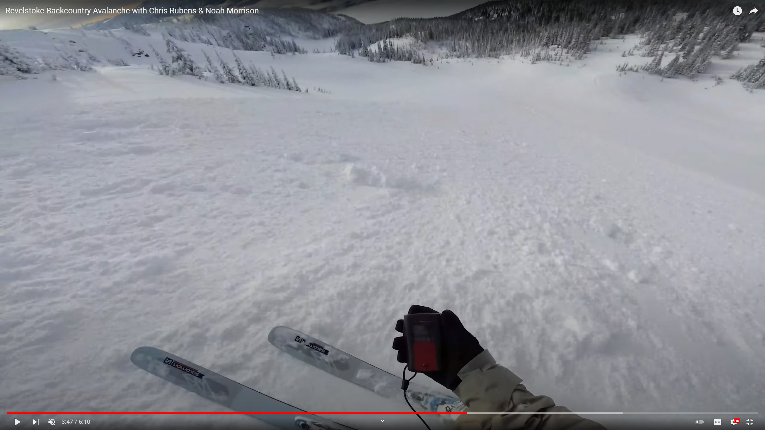 A skier holding a transceiver conducting an avalanche rescue.