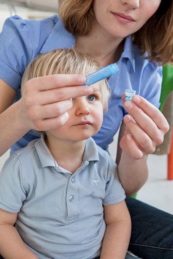 Homeopatie maminka podává dítěti granule