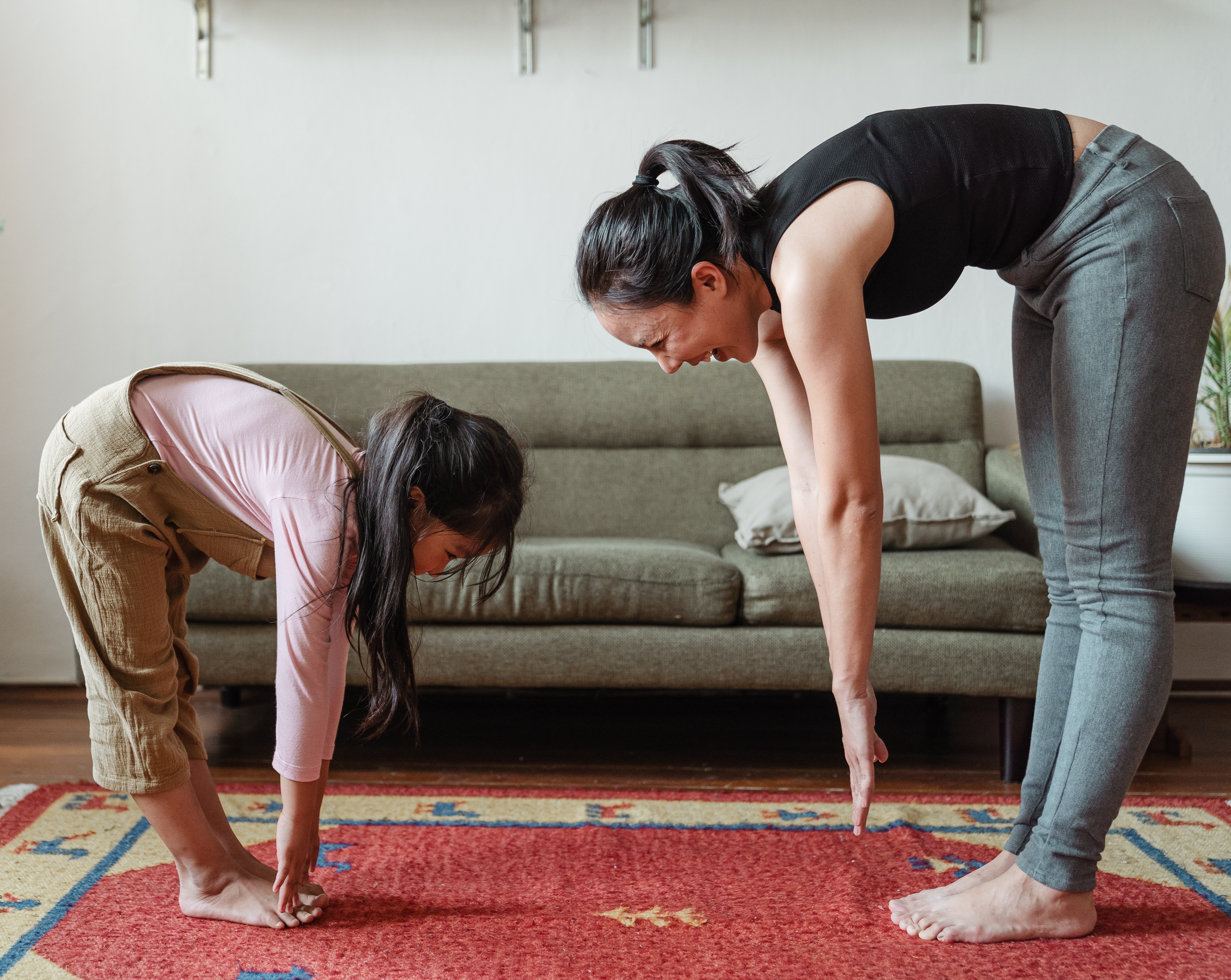 Mom stretching with her daughter in living room