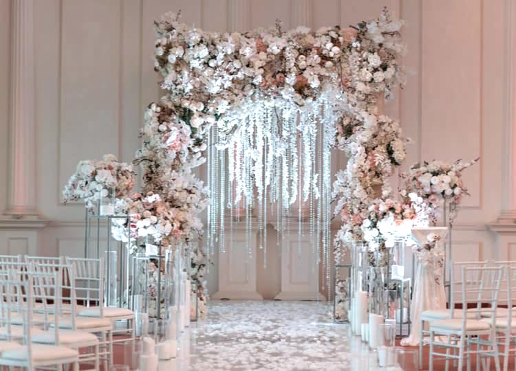 Kış teması kullanılarak dekor edilen düğün salonunda açık pembe ve beyaz çiçeklerden yapılmış bir alan bulunuyor.