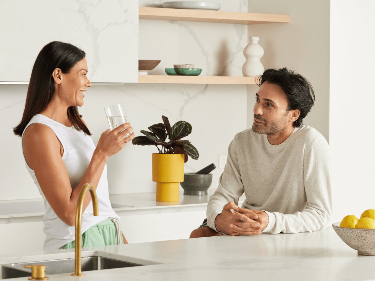 A man and a woman having a chat in the kitchen