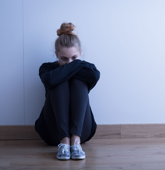 Berufsunfähigkeitsversicherung mit Depression - Frau sitzt deprimiert auf dem Boden berufsunfaehigkeitsversicherung-depression