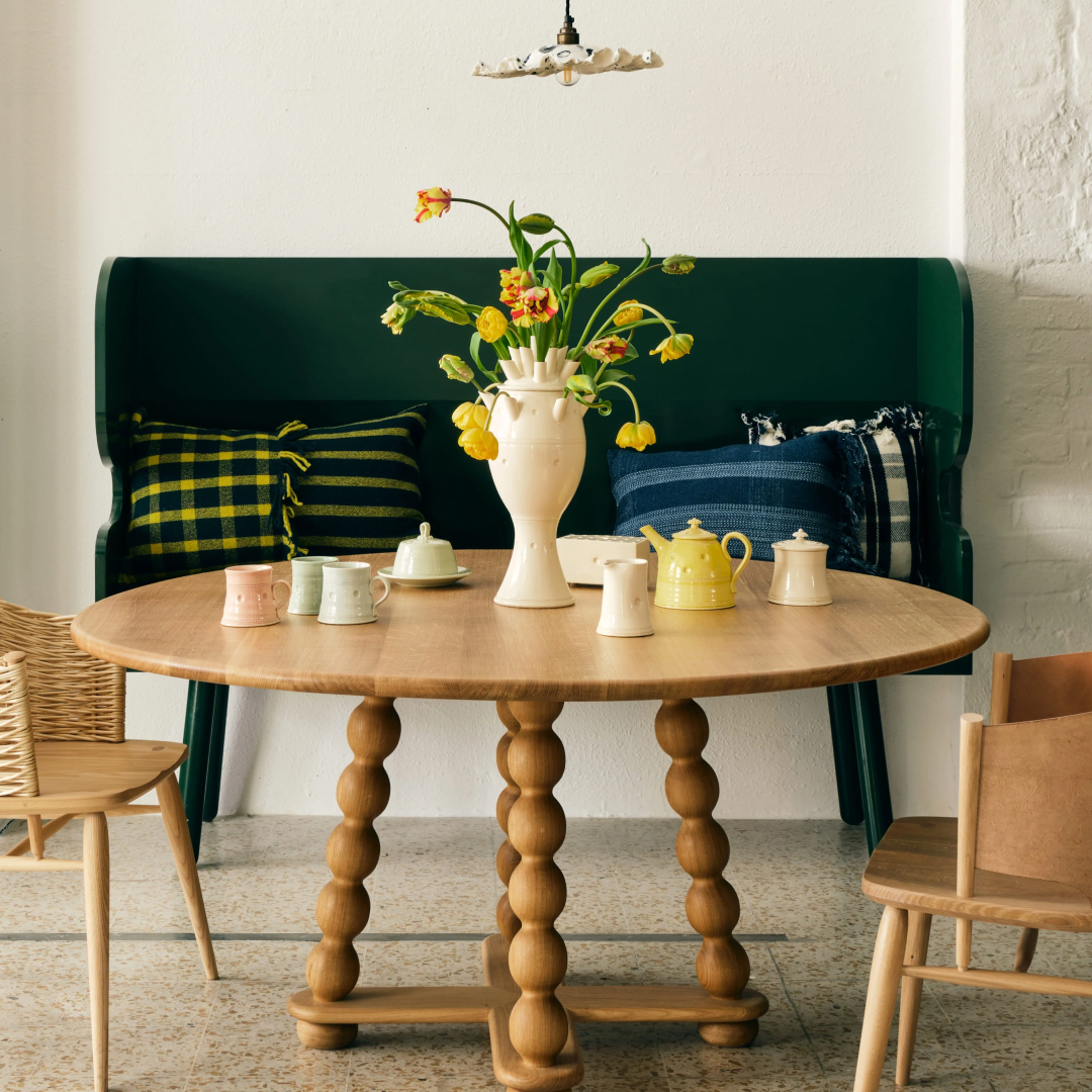 A round, wooden dining table with Bobbin legs