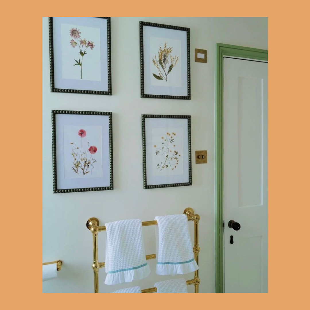 A bathroom wall with four prints framed in Bobbin frames