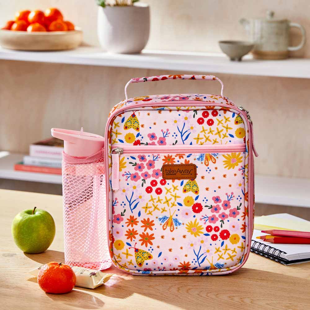 TakeAway Out Lunch Bag Set. Your Guide to Back to school preparation. Pink lunch bag with drink bottle on kitchen counter with fruit and books.