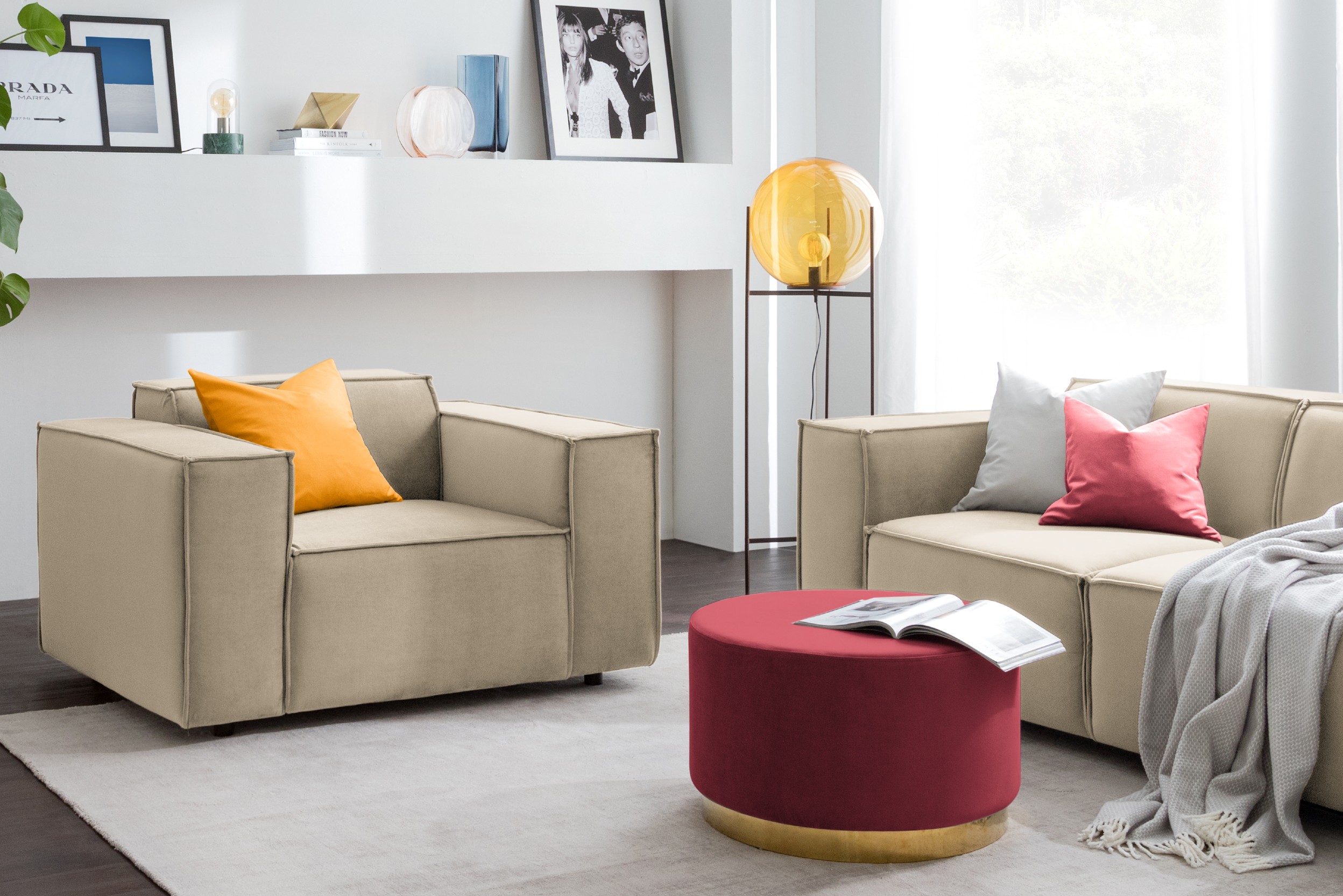 Sessel und Sofa mit rotem Pouf im Wohnzimmer