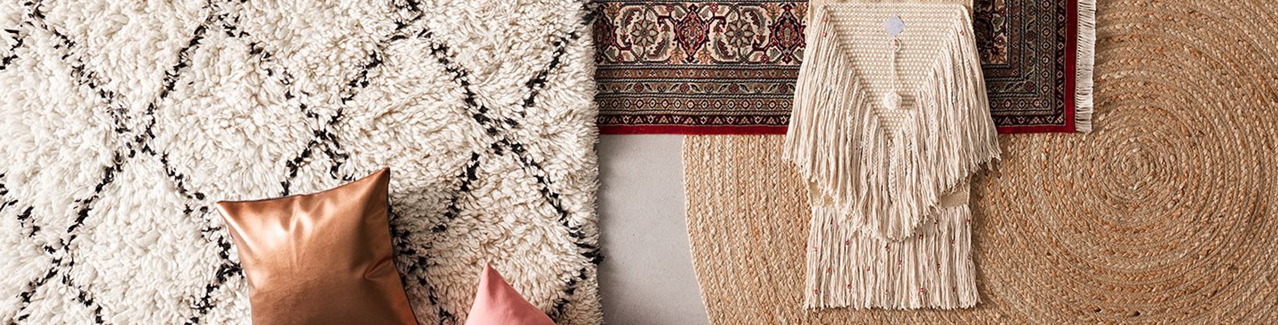 Heller Teppich mit Rautenmuster sowie Juteteppich ausgelegt mit Kissen und Boho-Deko