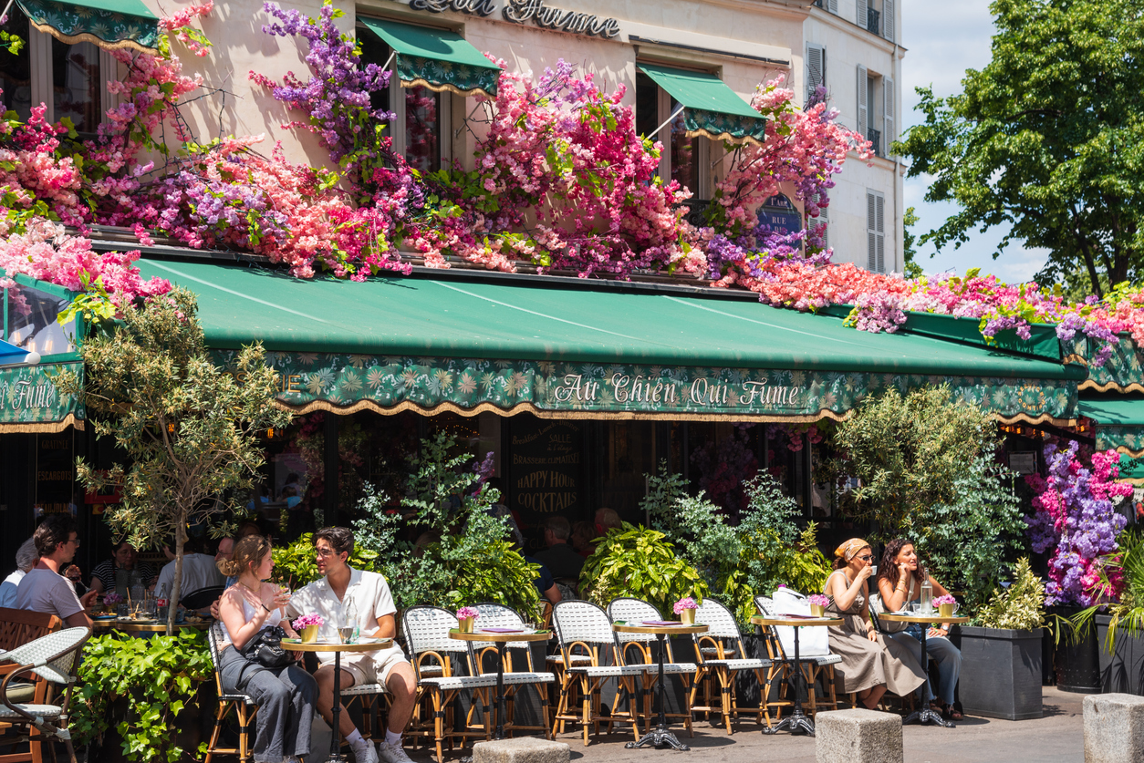 Terrasse de café parisien couvert de fleurs colorées