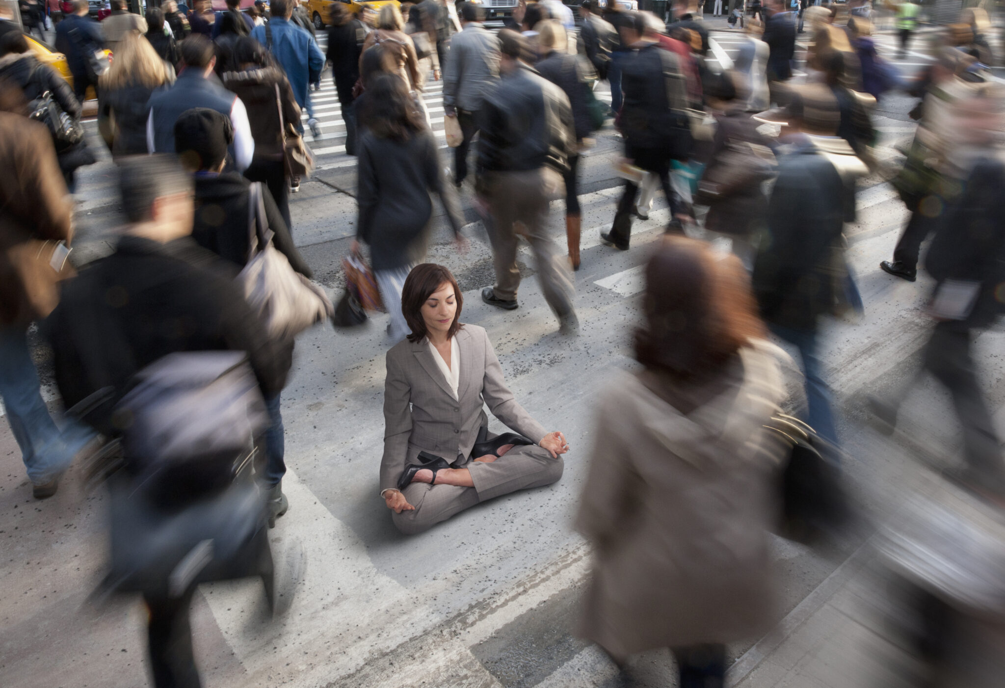 An office worker meditates on a busy crosswalk.