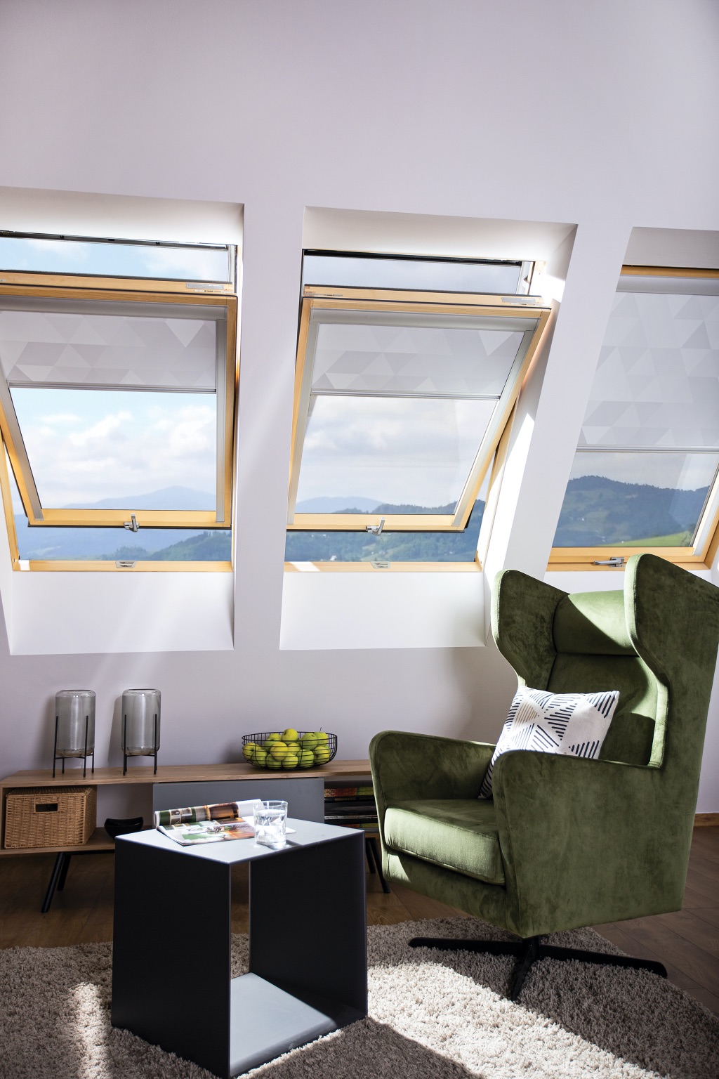 Drei Dachfenster in einem modernen Wohnbereich mit grünem Sessel Drei Dachfenster in einem modernen Wohnbereich mit grünem Sessel