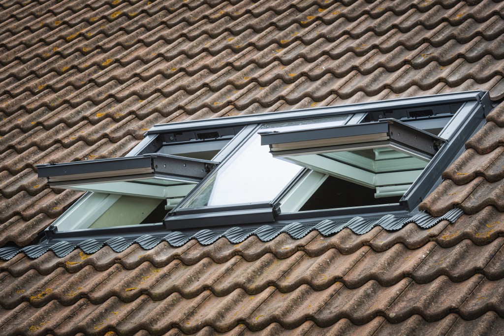 Hausdach mit zwei geöffneten Velux Dachfenstern