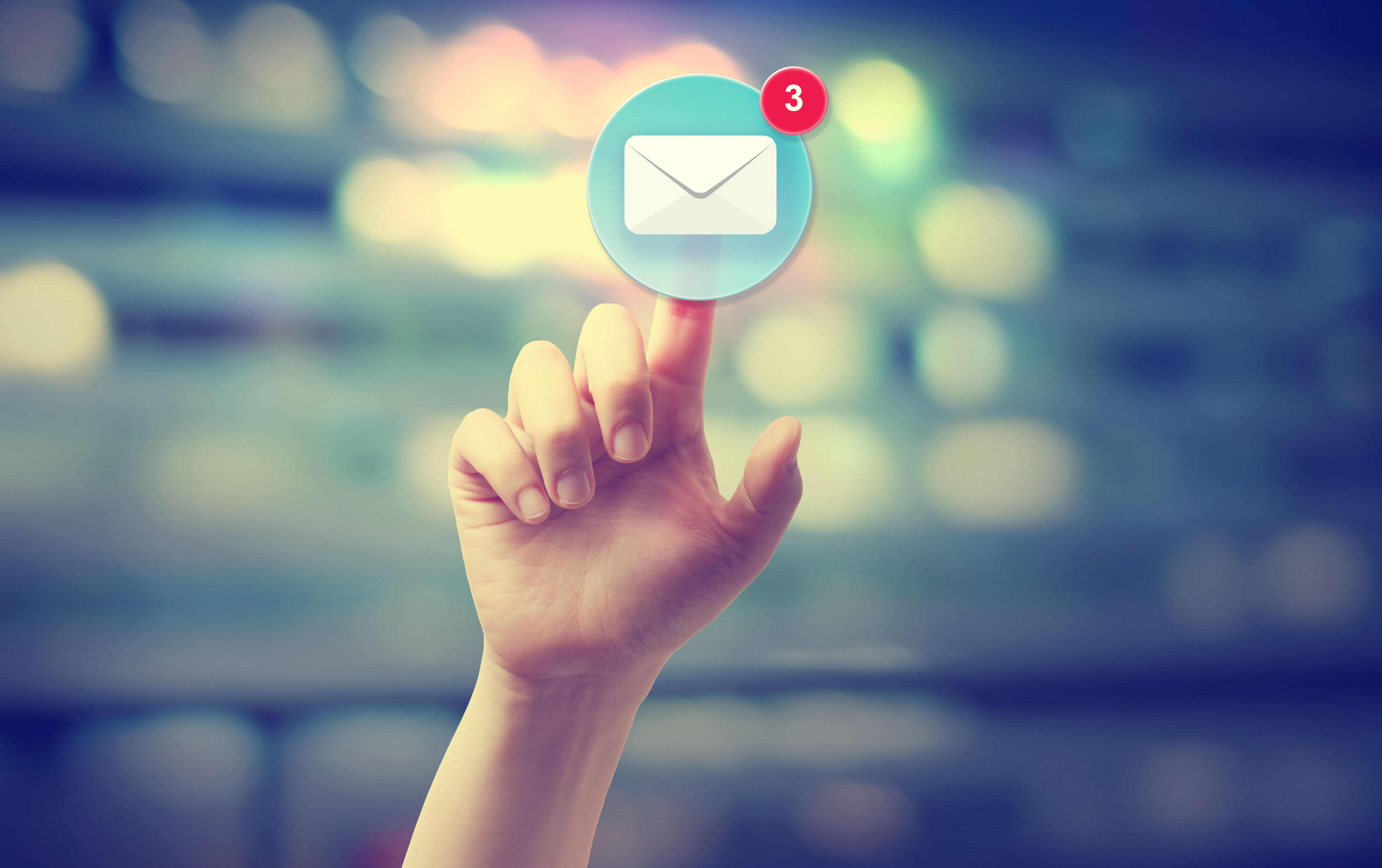A hand reaching up and pressing a button suspended in mid-air with an email icon on it
