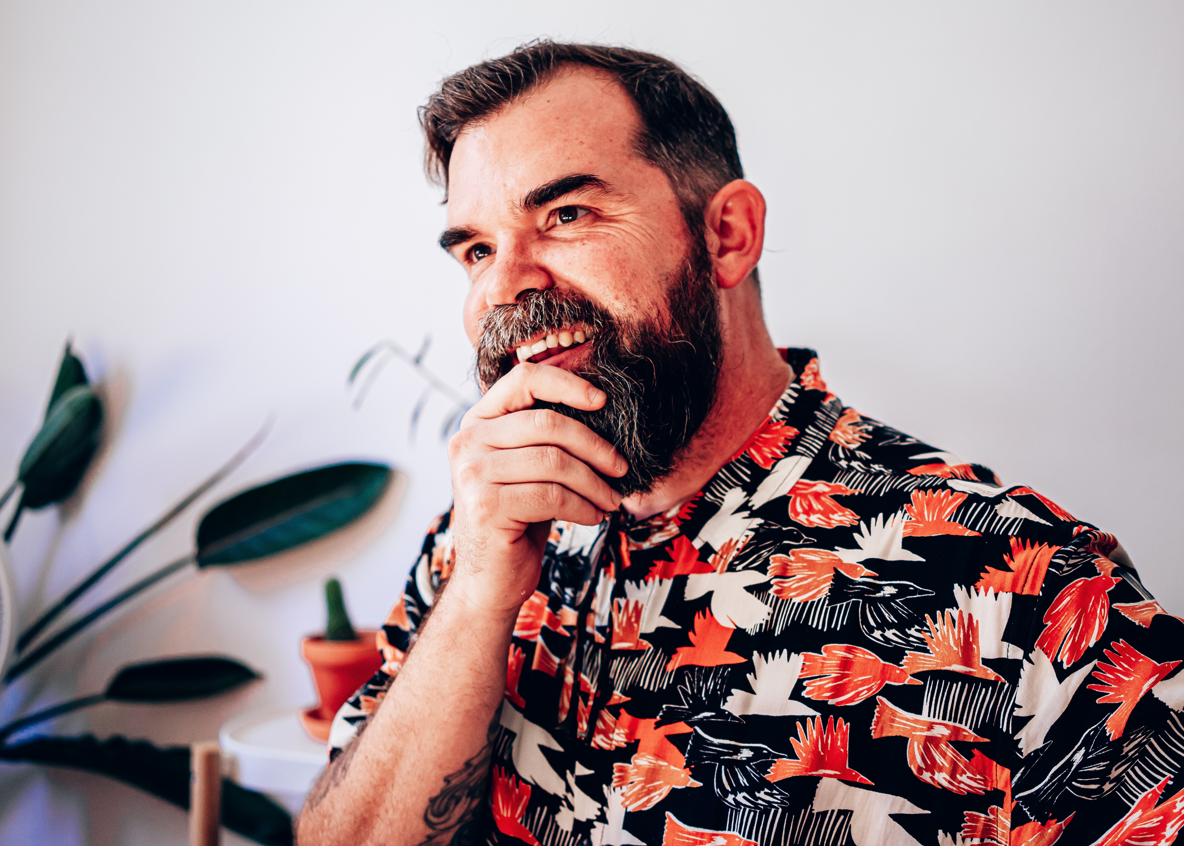 Smiling man holding his chin in a thoughtful pose.