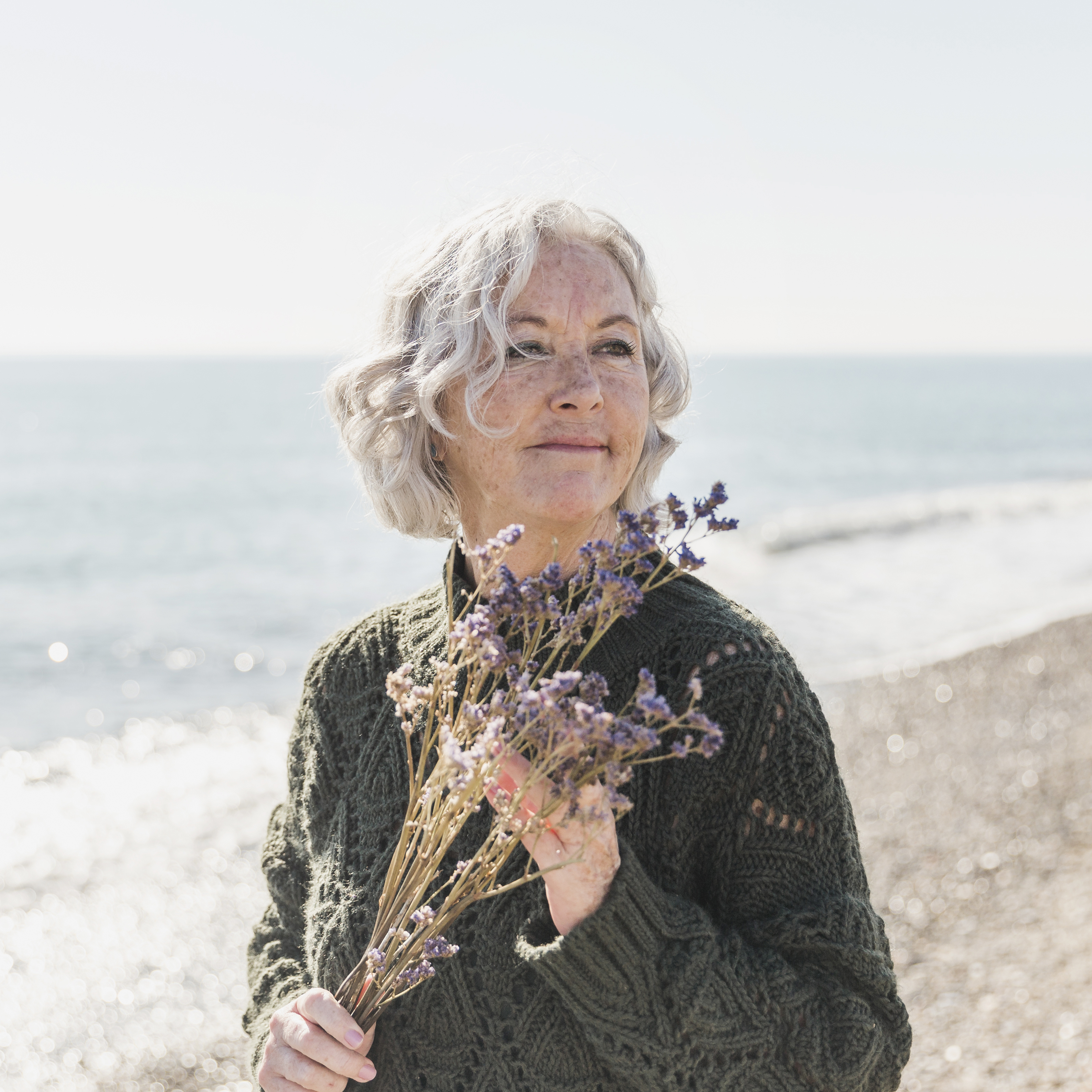 Woman with flowers at the beach