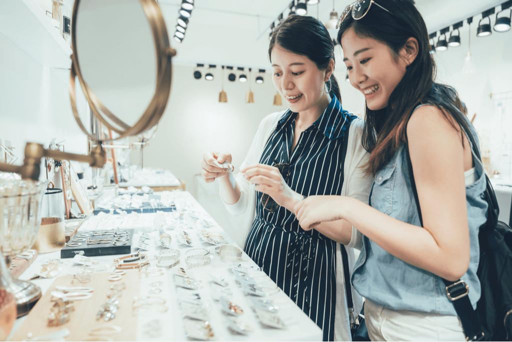 Two women enjoy looking at jewelry of many varieties in a store in Tokyo on a Sunday.