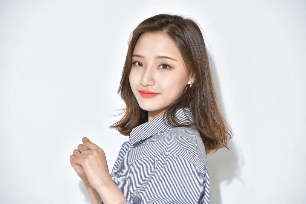 A woman smiles in front of a white background with a nice face of makeup using Japanese cosmetic brands