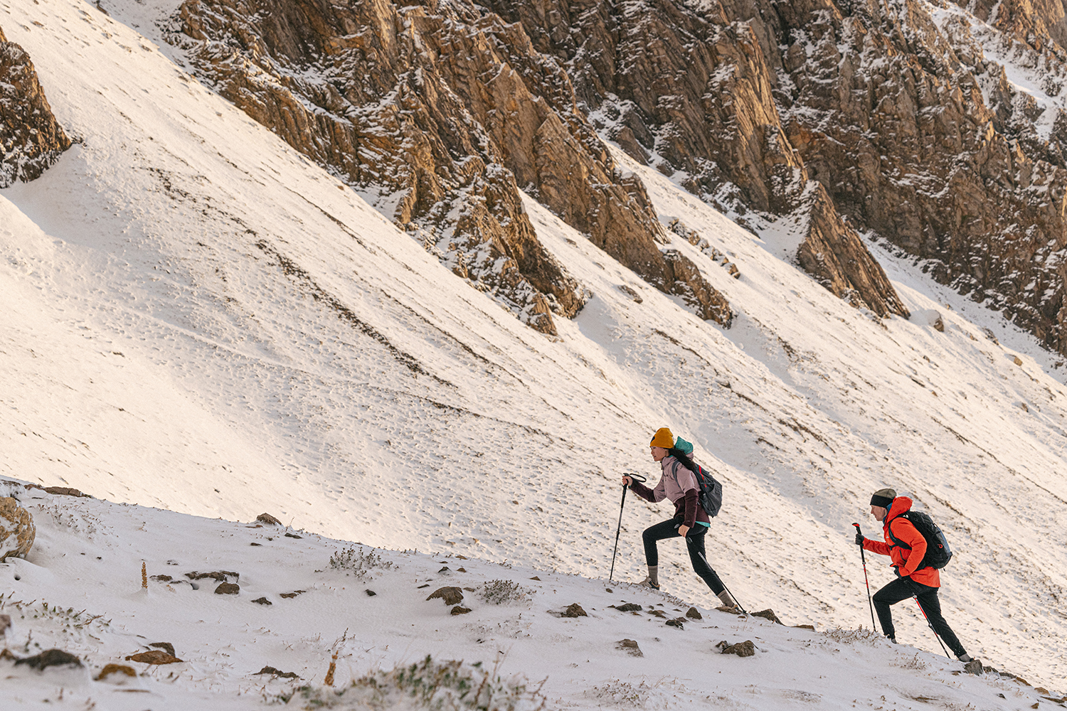 Two people hiking in the snow in the Katabatic Mid Waterproof boots.