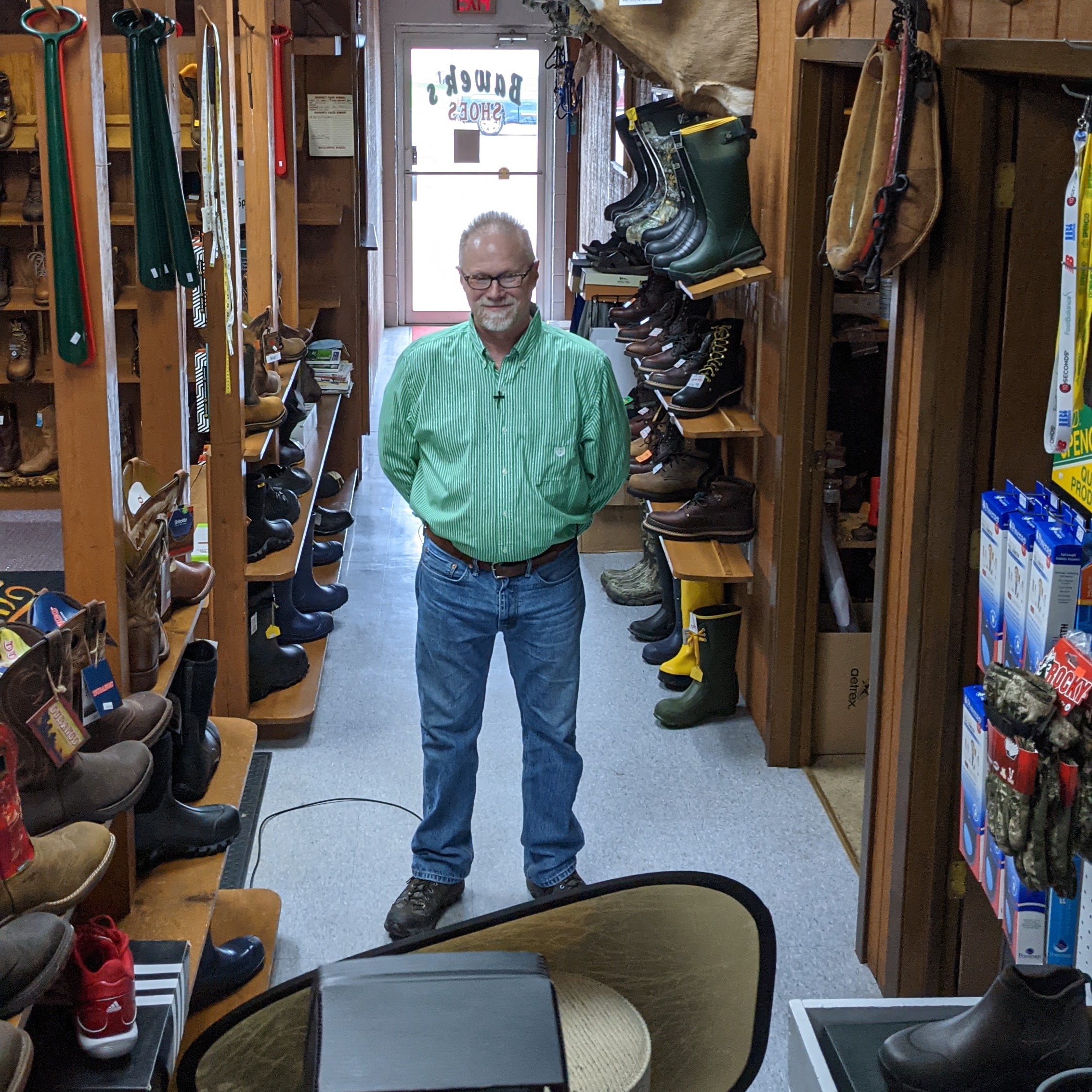 Craig Bawek of Bawek's Shoes stands within his store.