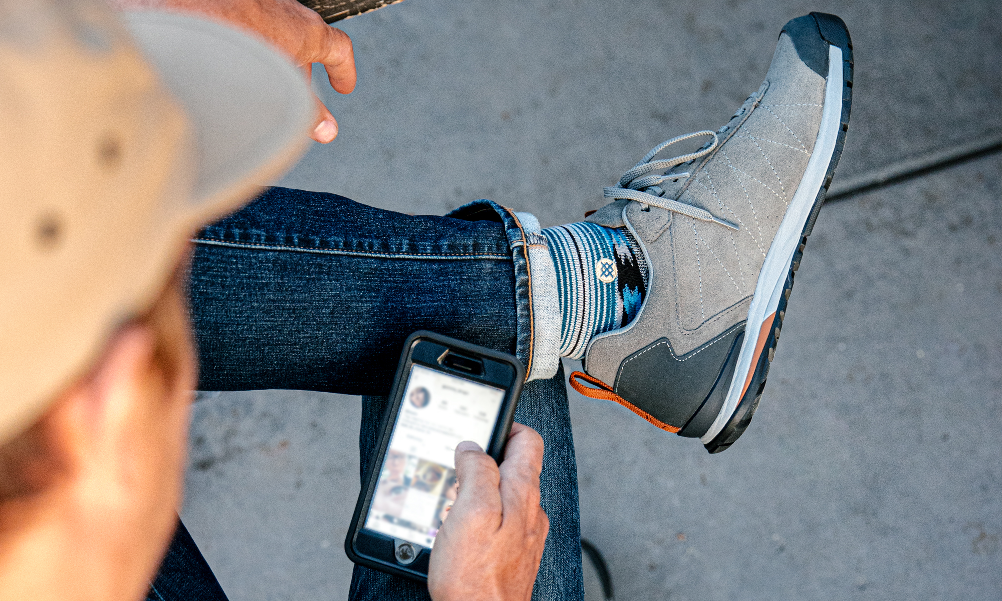 Man scrolling Instagram in the Oboz Bozeman Low Leather casual shoes.