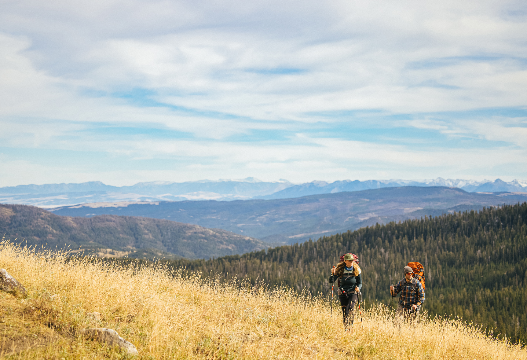 Two hikers bushwhacking a hike in the Montana mountains.