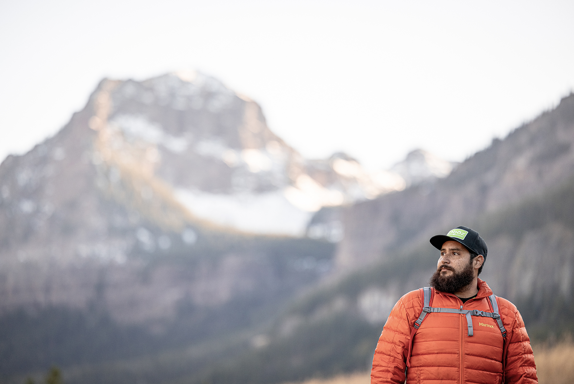 Man admiring a view of the mountains while hiking in an Oboz Footwear hat.