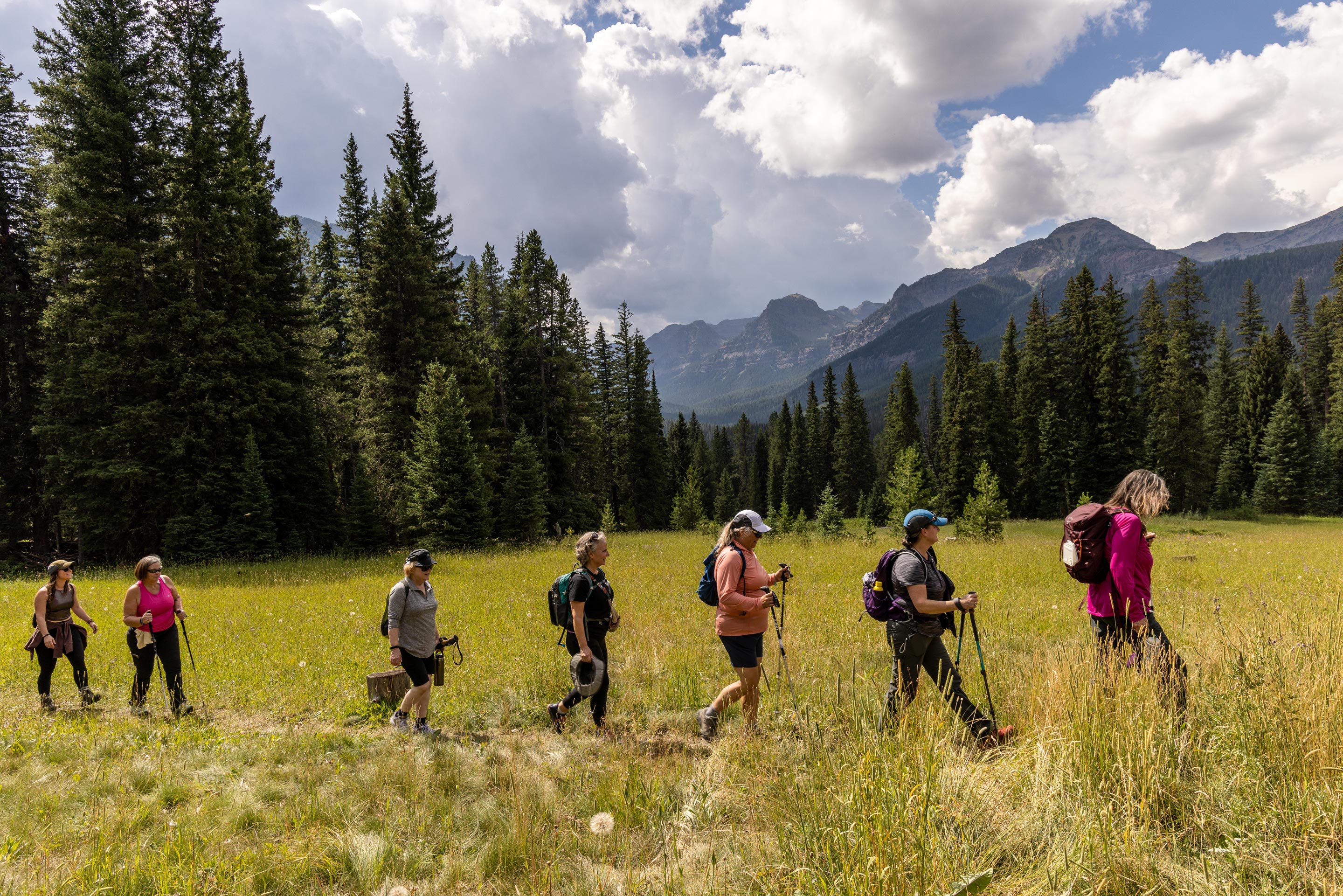 The women of the 52 Hike Challenge, hike through a meadow in Montana's Hyalite Valley.