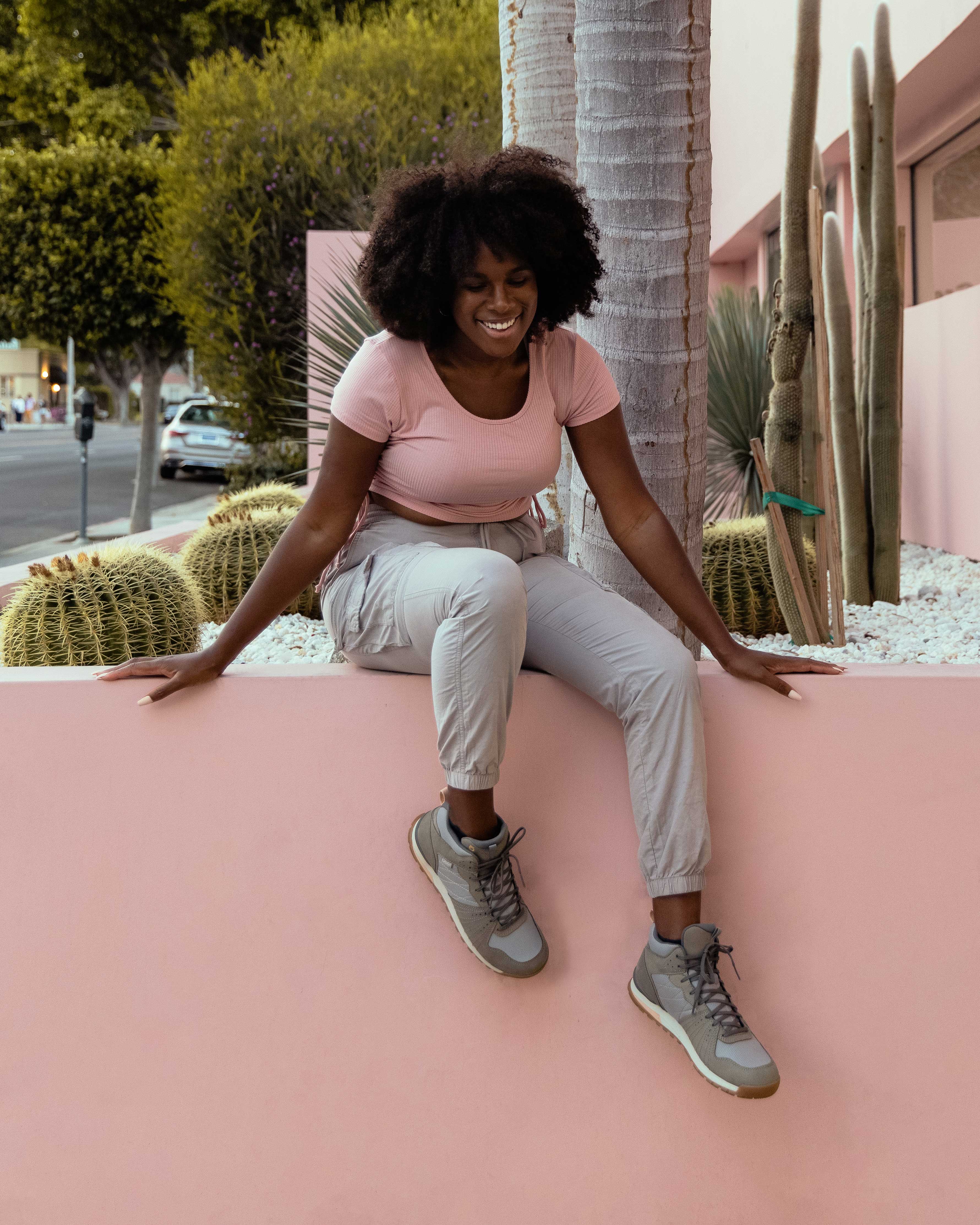A person relaxing on a ledge wearing Oboz Women's Bozeman Mid casual shoes.