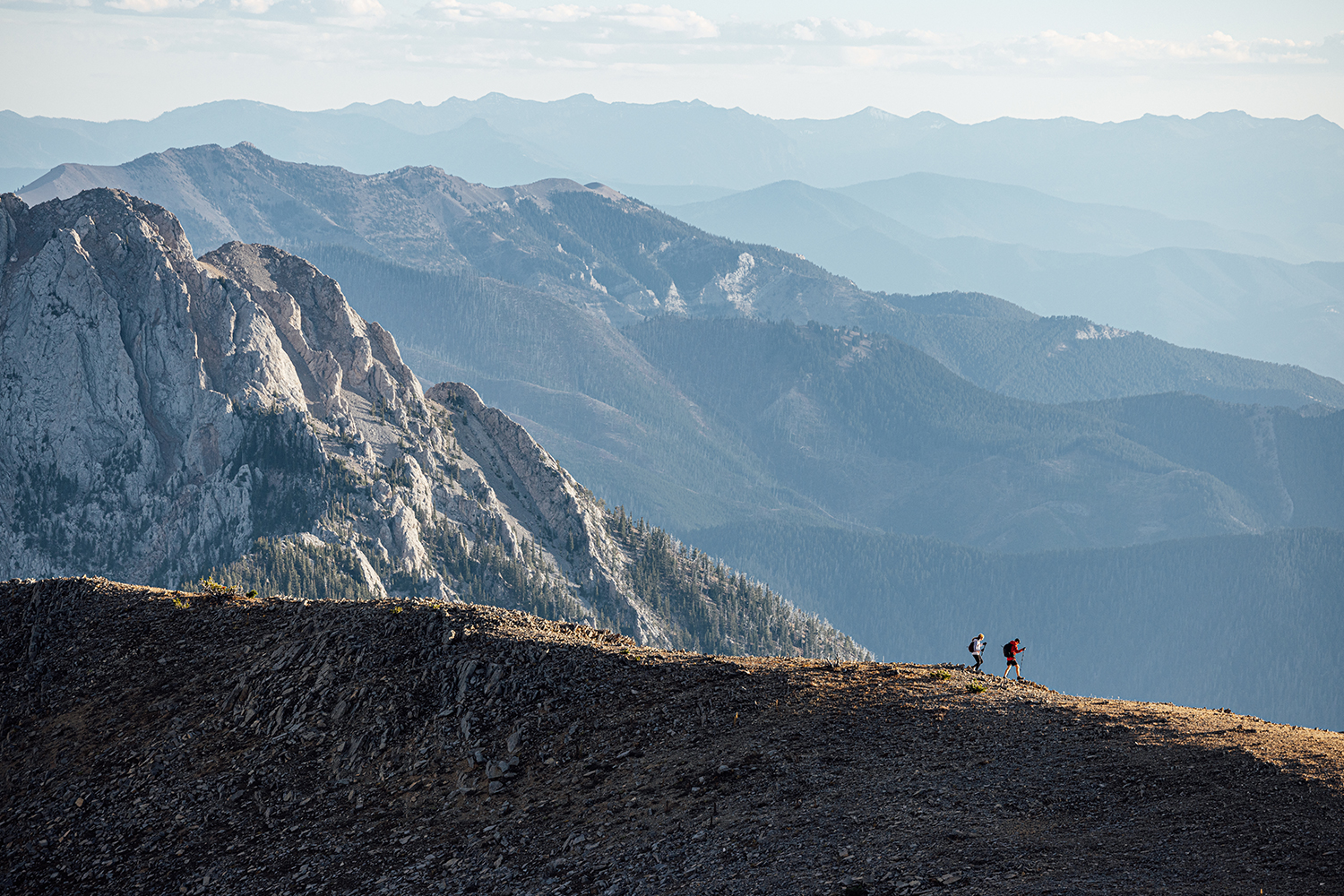 Two runners on ridgeline in the Bridger Mountain Range near Bozeman, MT.
