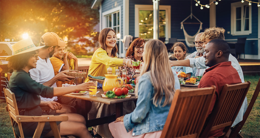 Family eating on wooden garden furniture