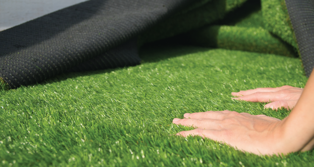 Lanscaper pressing on artificial grass