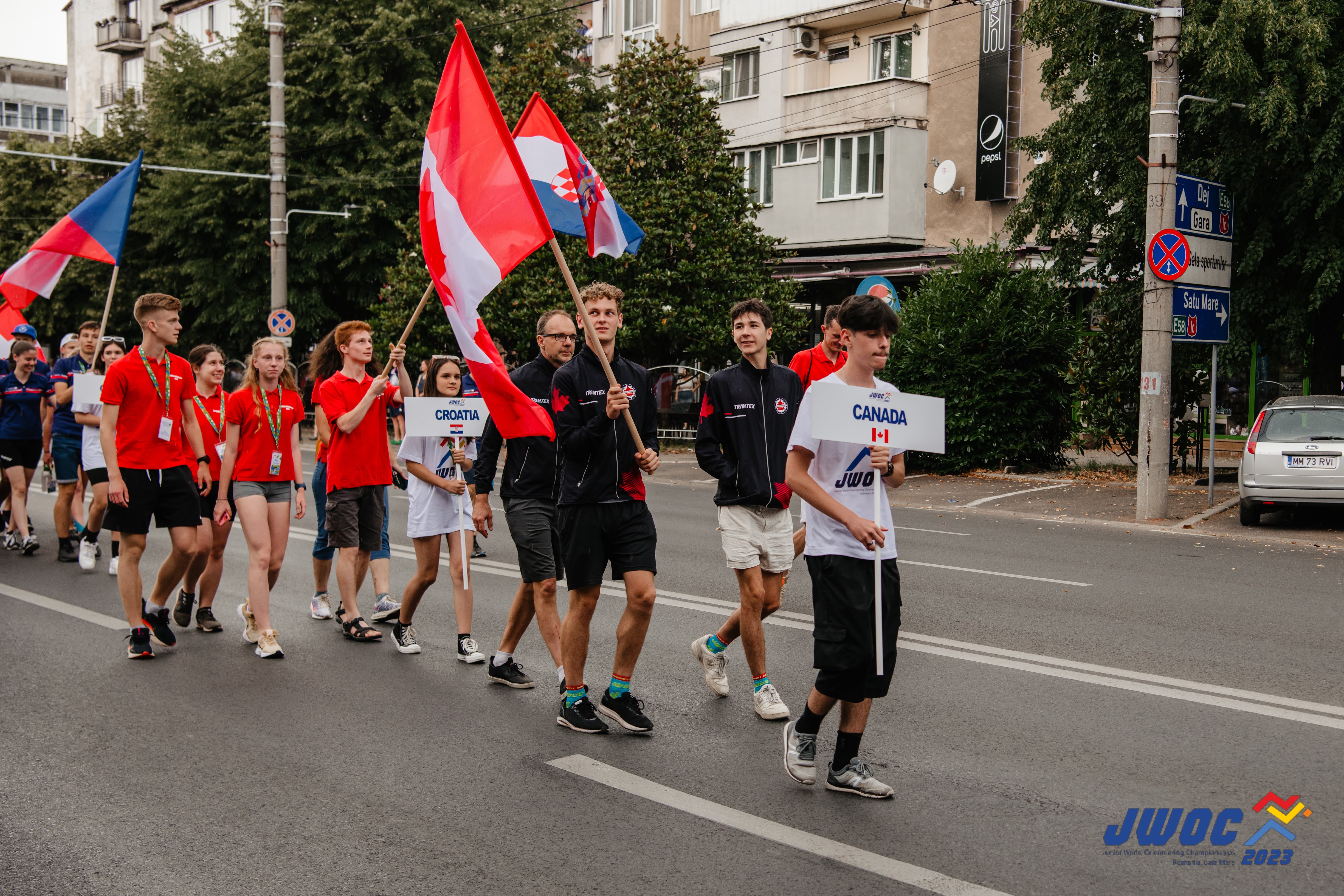 Team Canada walking in opening ceremonies with Canadian flag at JWOC 2023. 