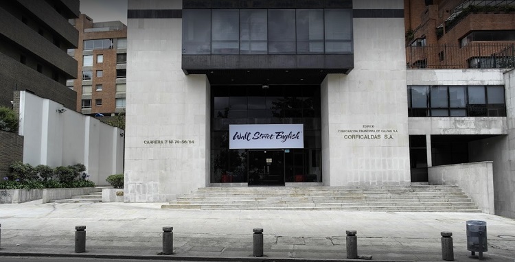 Fachada de Wall Street English en Bogotá | Edificio color cemento con cartel de la escuela 