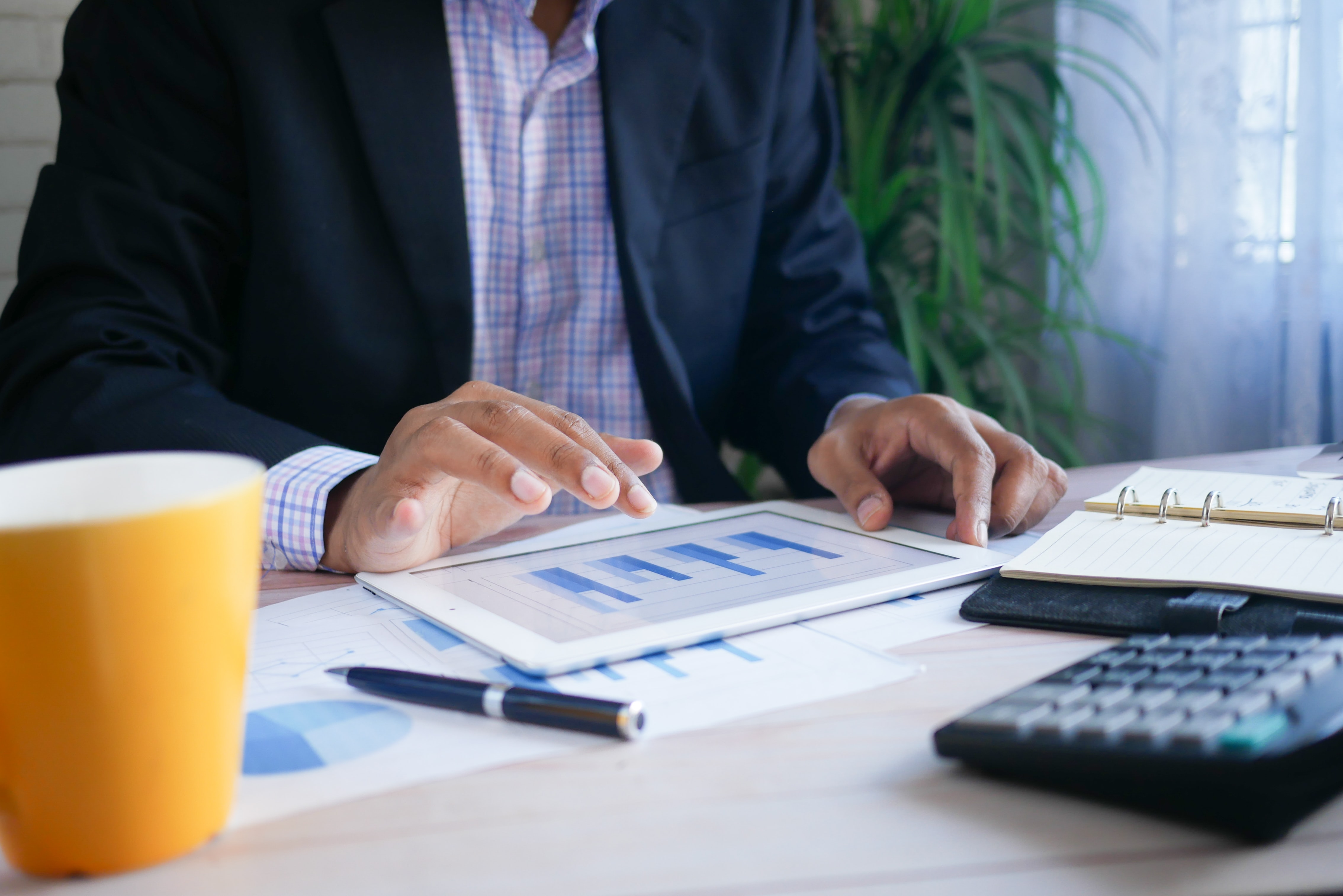 Banker holding tablet reviewing charts