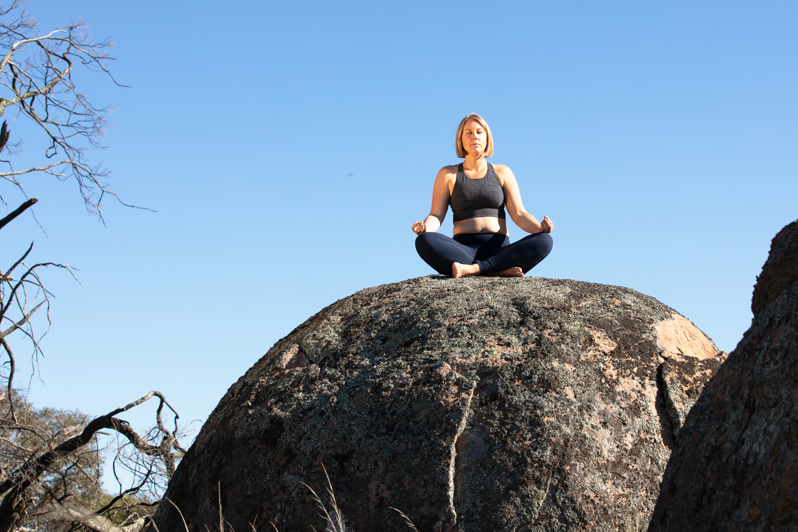 Camilla Sinclair meditating on rock