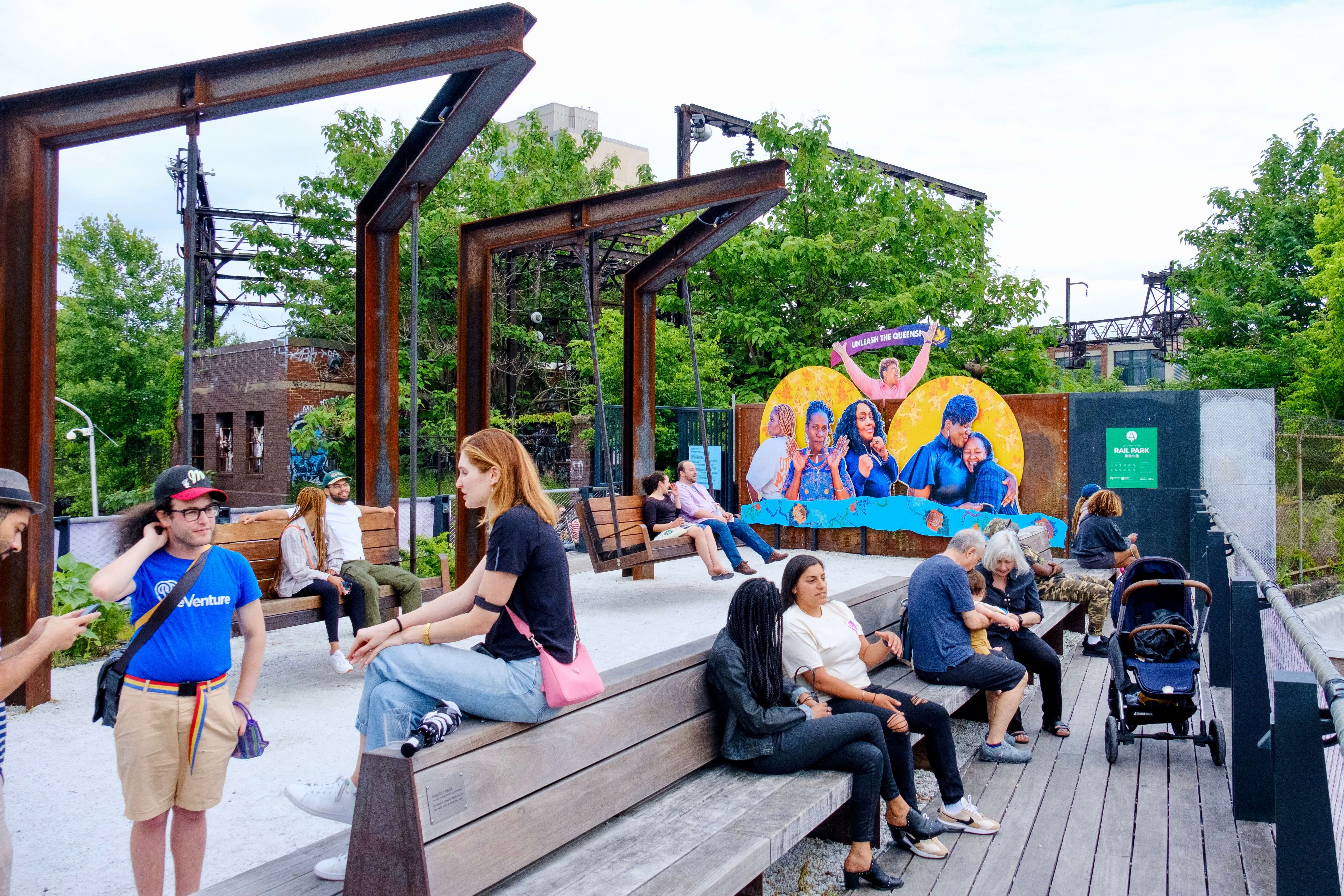 People hang out at the Rail Park with the Liberation Journeys display in the background