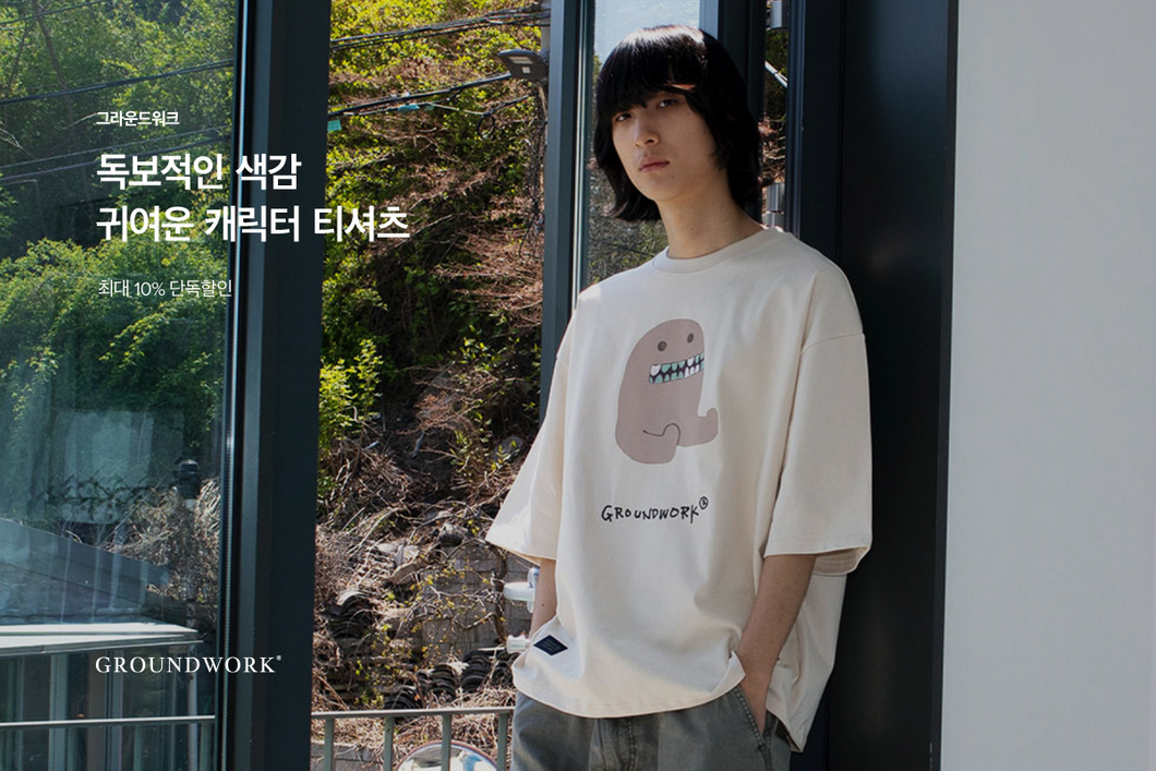 A man wearing a white cartoon pattern t-shirt from ÅLAND a multi-brand from Korea.