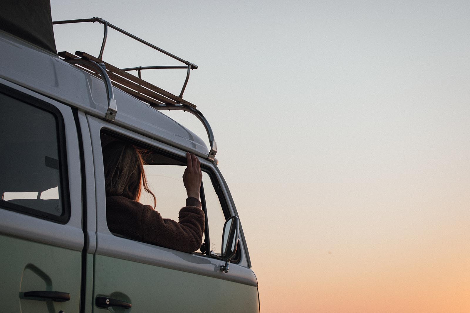 Woman in a camper searching for top wild camping locations in Portugal.