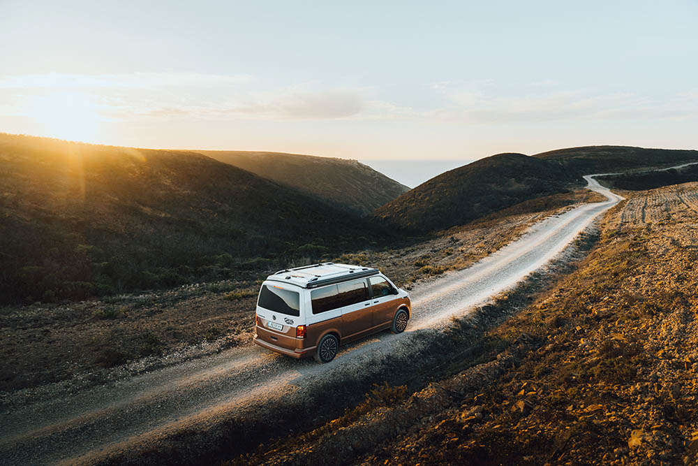 Voyageurs dans un camping-car profitant d'un temps ensoleillé lors d'un aventure hivernale au Portugal. 